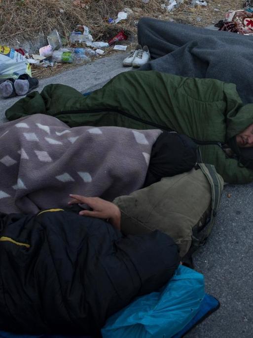 Nach einem Brand im Lager Moria auf der Insel Lesbos schlafen Flüchtlinge obdachlos am Straßenrand.