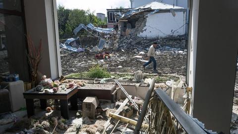 Aserbaidschan, Stepanakert: Ein Mann geht an einem Haus vorbei, das von der aserbaidschanischen Artillerie durch Beschuss zerstört wurde.