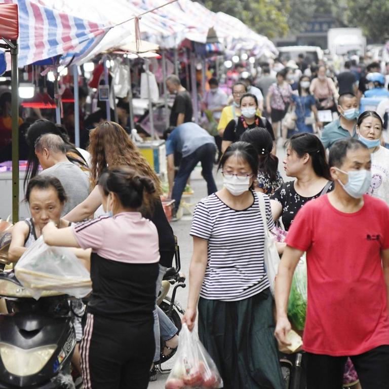 Leben in Wuhan - Menschen kaufen in der Innenstadt auf einem Markt ein