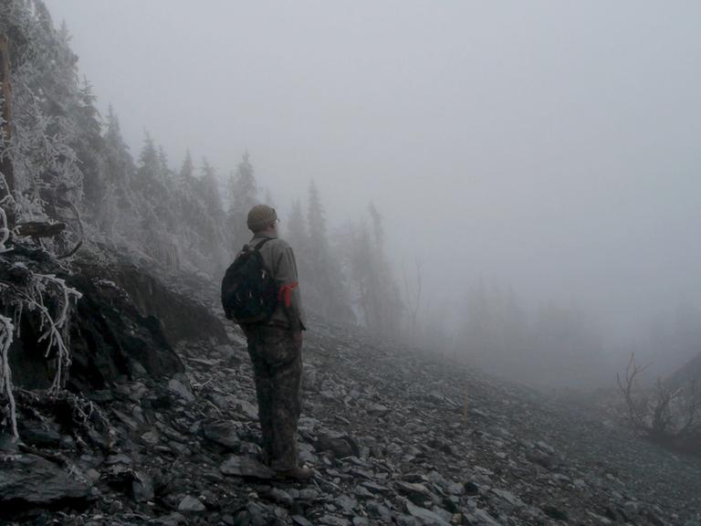 Im Still aus "Planet of the Humans" steht ein Mann im Nebel.