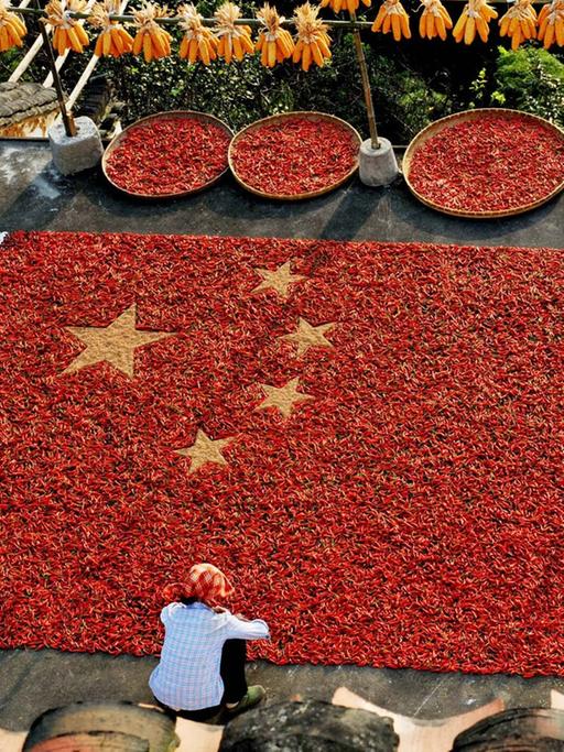 Chinesische Bauern basteln eine große chinesische Flagge aus getrockneten Chili-Schoten am Nationalfeiertag in der Stadt Shangrao, ostchinesische Jiangxi Provinz, aufgenommen 2014.