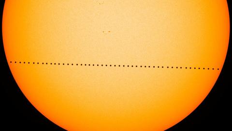 Vor der Sonnenscheibe ist der Merkur als kleiner schwarzer Punkt zu erkennen.
