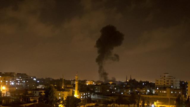 Eine Rauchfahne über den erleuchteten Häusern im nächtlichen Gaza-Stadt