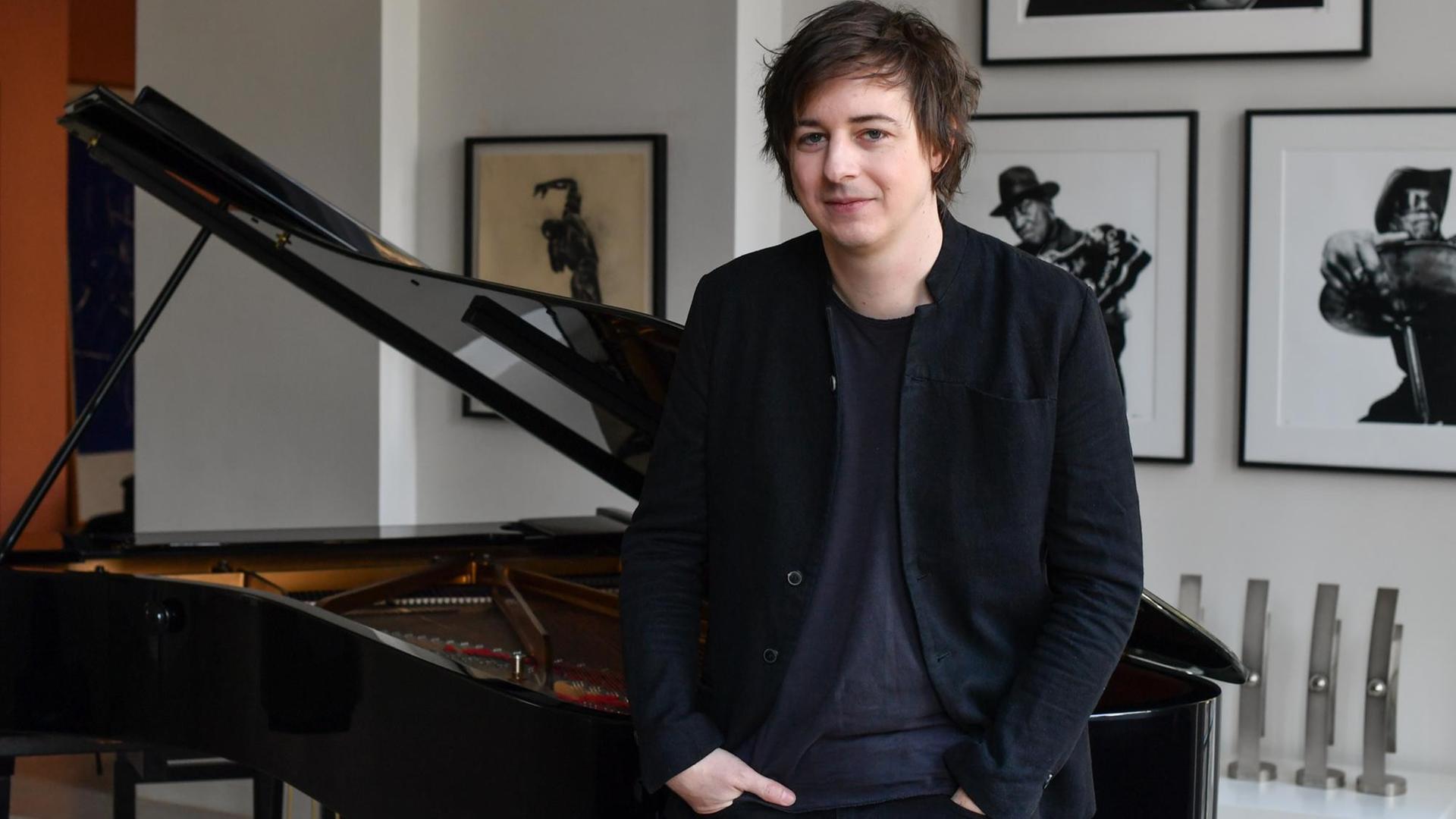 Michael Wollny, deutscher Jazzpianist, steht bei einem Fototermin in Berlin an einem Klavier.
