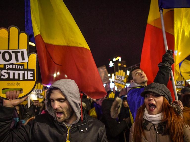Menschen protestieren in der rumänischen Hauptstadt mit Fahnen in den Landesfarben und mit Slogans gegen die geplante Justizreform