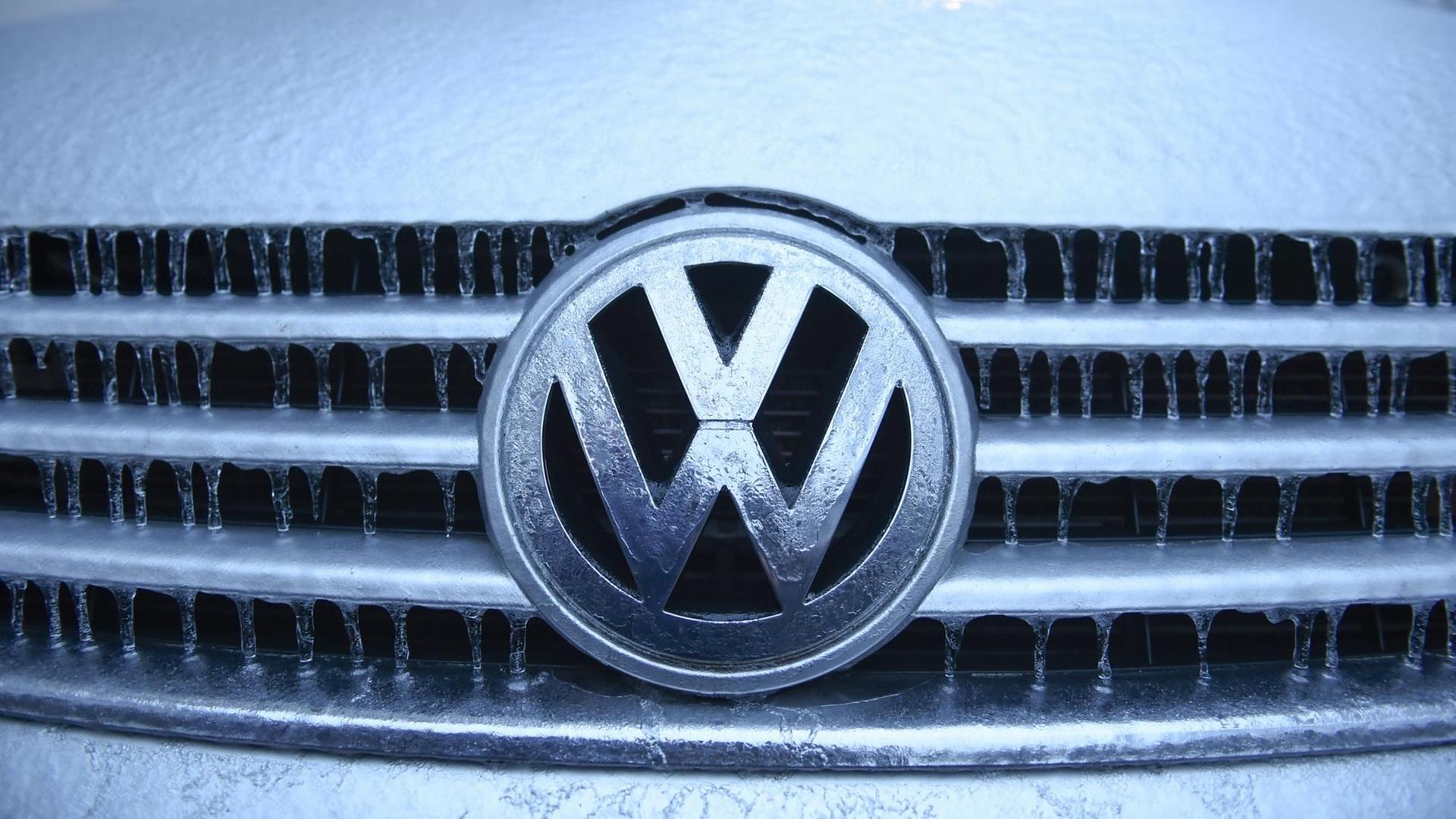 Eiszapfen und Eisschicht haben sich nach einem Eisregen auf einem VW-Logo gebildet.