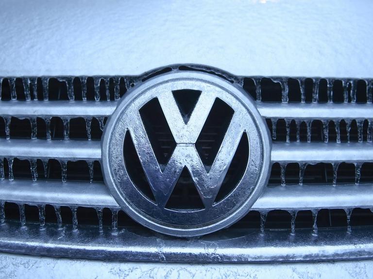 Eiszapfen und Eisschicht haben sich nach einem Eisregen auf einem VW-Logo gebildet.
