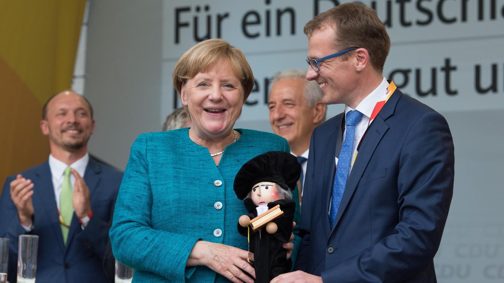 Bundeskanzlerin Angela Merkel (CDU) erhält bei einem Wahlkampfauftritt in Annaberg-Buchholz (Sachsen) am 17.03. 2017 von dem CDU-Landtagsabgeordneten Alexander Krauß (r) einen Martin Luther Nussknacker.