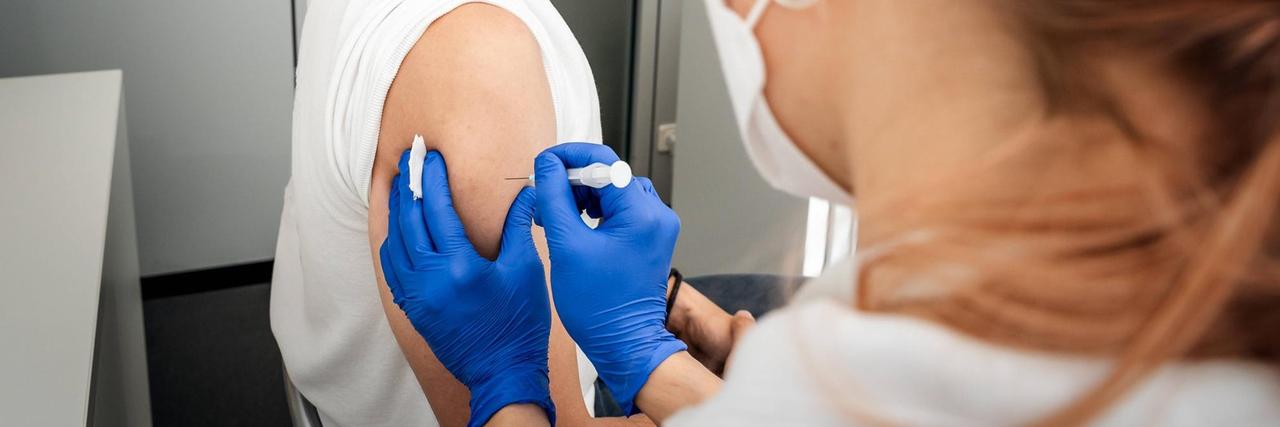 Eine Ärztin in Augsburg impft einen Impfling gegen Covid19.