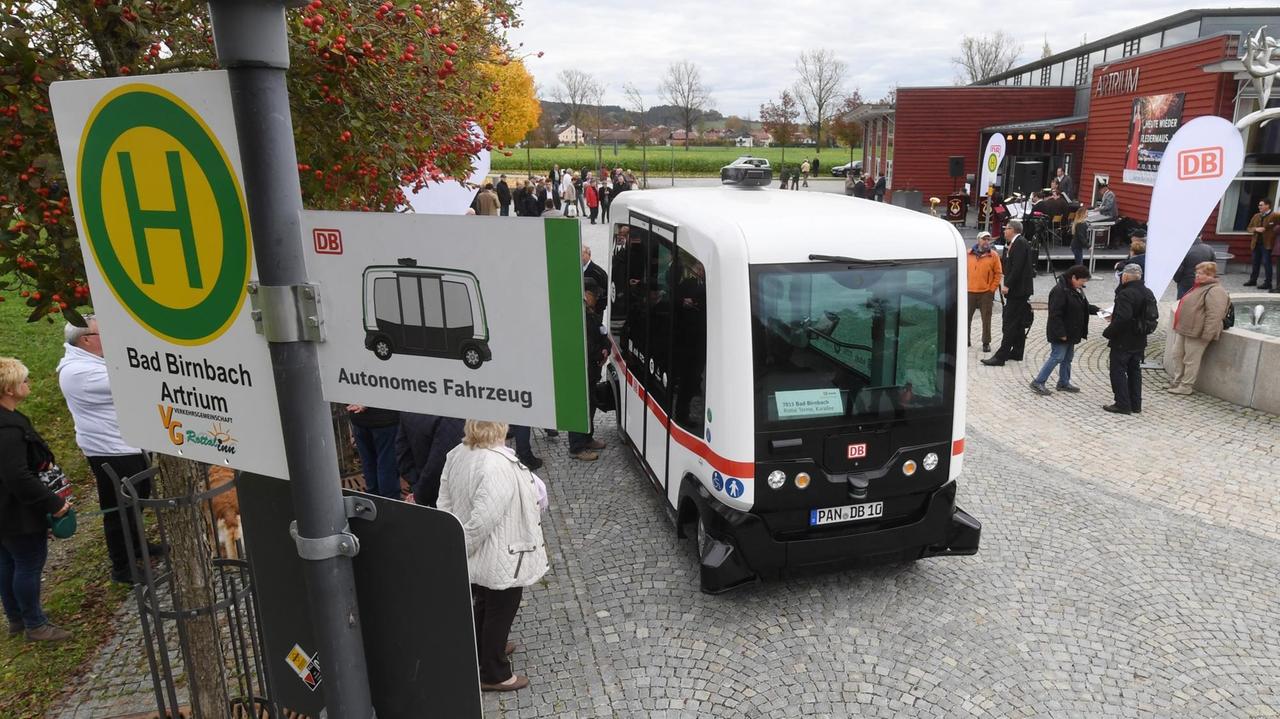 Ein autonom-fahrender Mini-Bus fährt am 25.10.2017 in Bad Birnbach (Bayern) auf einer Straße und wird von Passanten betrachtet