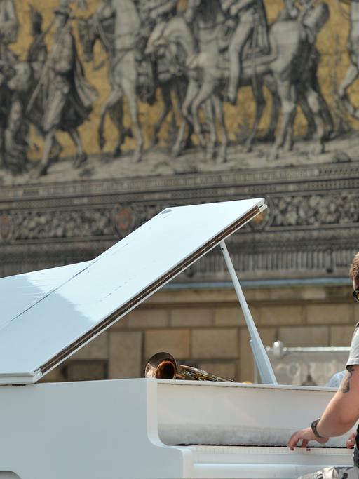 Ein Pianist spielt in Dresden vor dem Fürstenzug