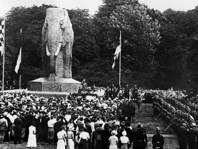 Historisches Schwarz-Weiß-Bild einer Festgesellschaft, die in Bremen um ein Denkmal in Form eines großen steinernen Elefanten versammelt.