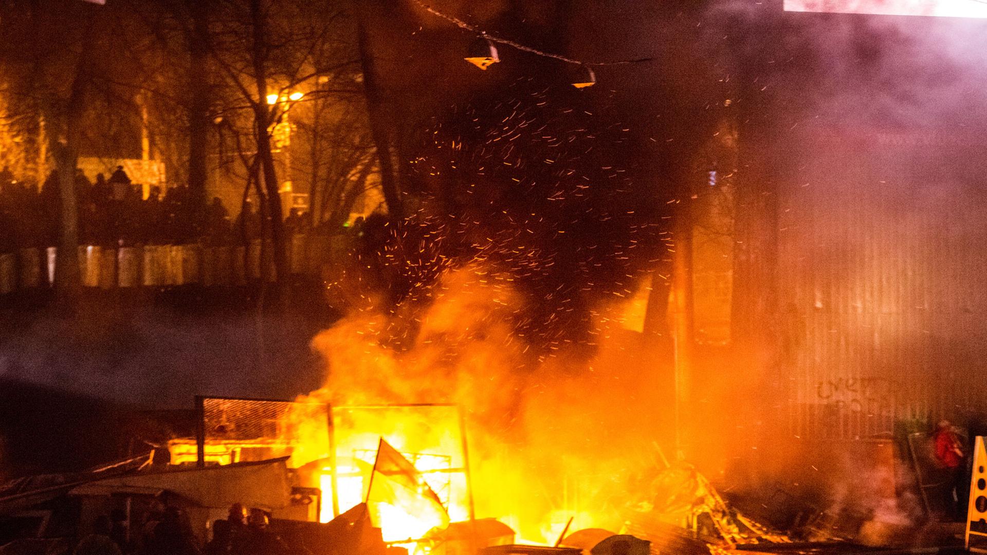 In der Nähe des Dynamo-Stadions in der ukrainischen Hauptstadt brennt ein Feuer während der Straßenschlachten, Funken fliegen durch die Dunkelheit.