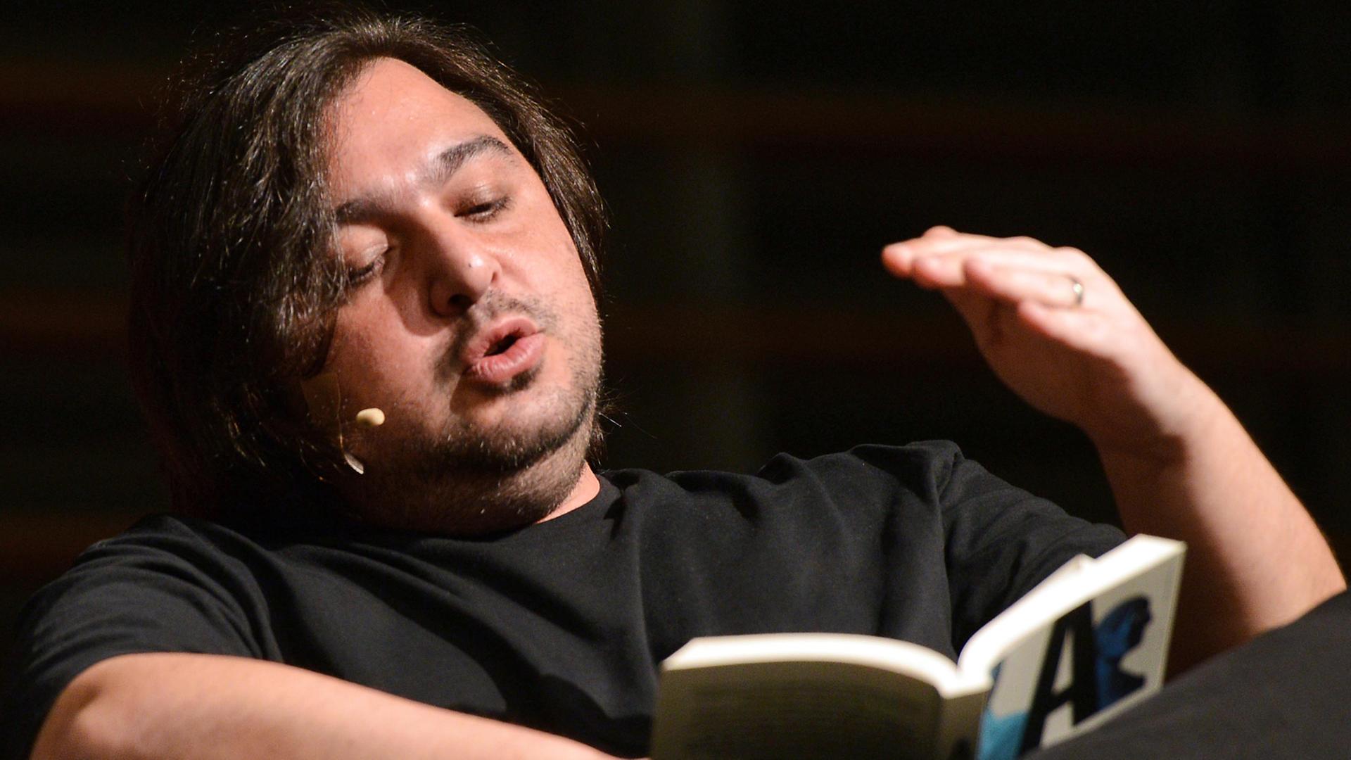 Der Autor Hakan Günday sitzt am 14.03.2014 bei einer Lesung im Rahmen des Literaturfestivals lit.Cologne in Köln (Nordrhein-Westfalen) auf der Bühne, wo er sein Buch "Extrem" vorstellt.