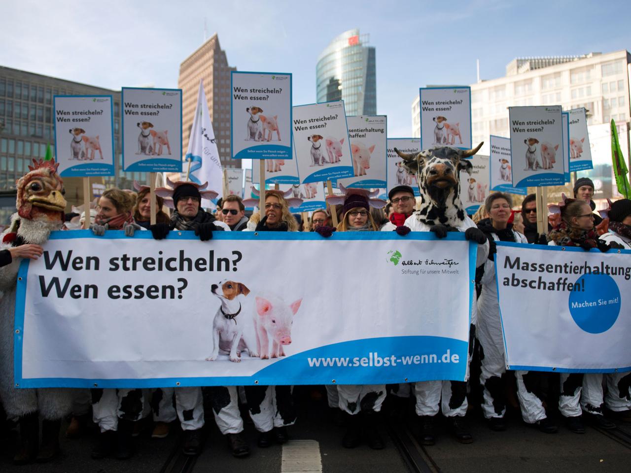 Demonstrationsteilnehmer marschieren mit einem Plakat mit der Aufschrift "Wen streicheln? Wen essen?".