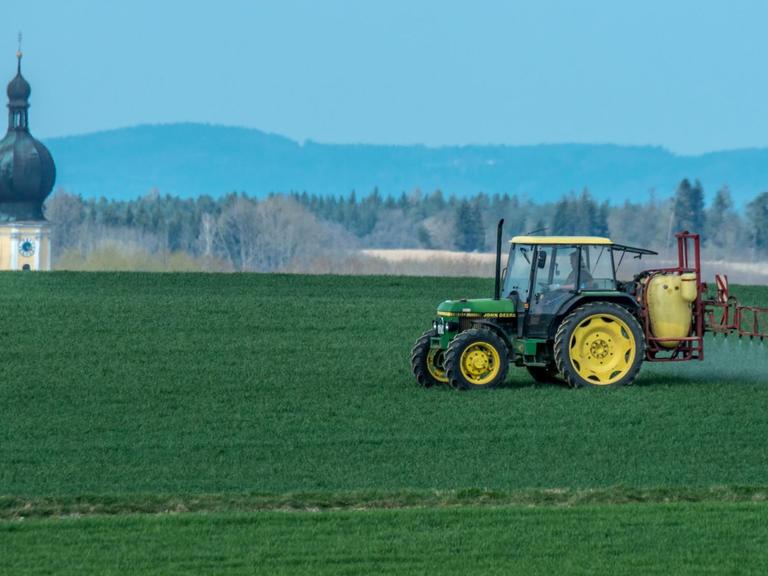 Mit einem Traktor wird nahe Sallach im Landkreis Straubing-Bogen (Bayern) Pflanzenschutzmittel auf ein Feld gespritzt.