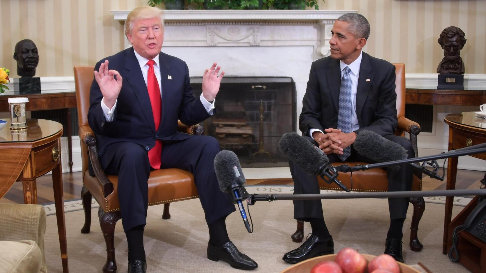 US-Präsident Barack Obama (r) und sein gewählter Nachfolger Donald Trump (l) sitzen nebeneinander auf Sesseln im Weißen Haus.