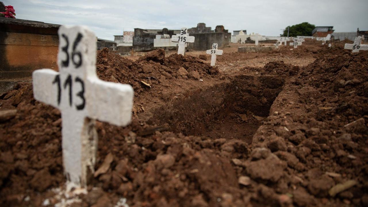 Ein einfaches Kreuz ohne Namen und mit einer Nummer steht an einem offenen Grab am Friedhof von Iraja. Ursprünglich für die Armen vorgesehen, sind die Gräber ohne Namen in der Corona-Pandemie zu eine der wenigen erschwinglichen Optionen für viele Familien geworden, Angehörige zu begraben.