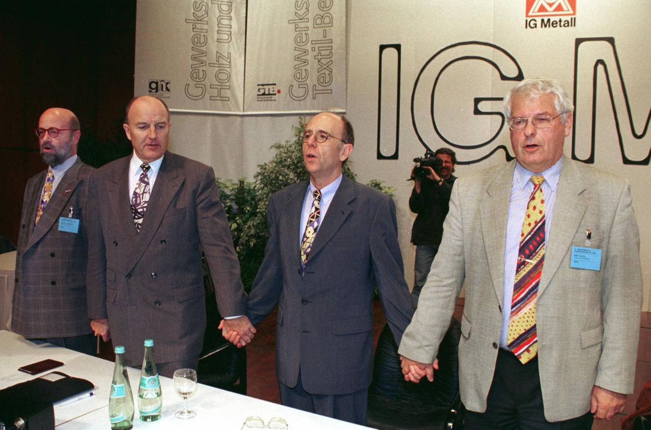Hand in Hand: Zum Abschluß des 4. außerordentlichen Gewerkschaftstages der IG Metall am 11.10.1997 in Mannheim singen (l-r) die Vorsitzenden von IG Holz und Kunststoff (GHK), Gisbert Schlemmer, IG Metall, Klaus Zwickel, der 2. Metall-Vorsitzende Walter Riester und IG Textil und Bekleidung (GTB), Willi Arens, gemeinsam. 