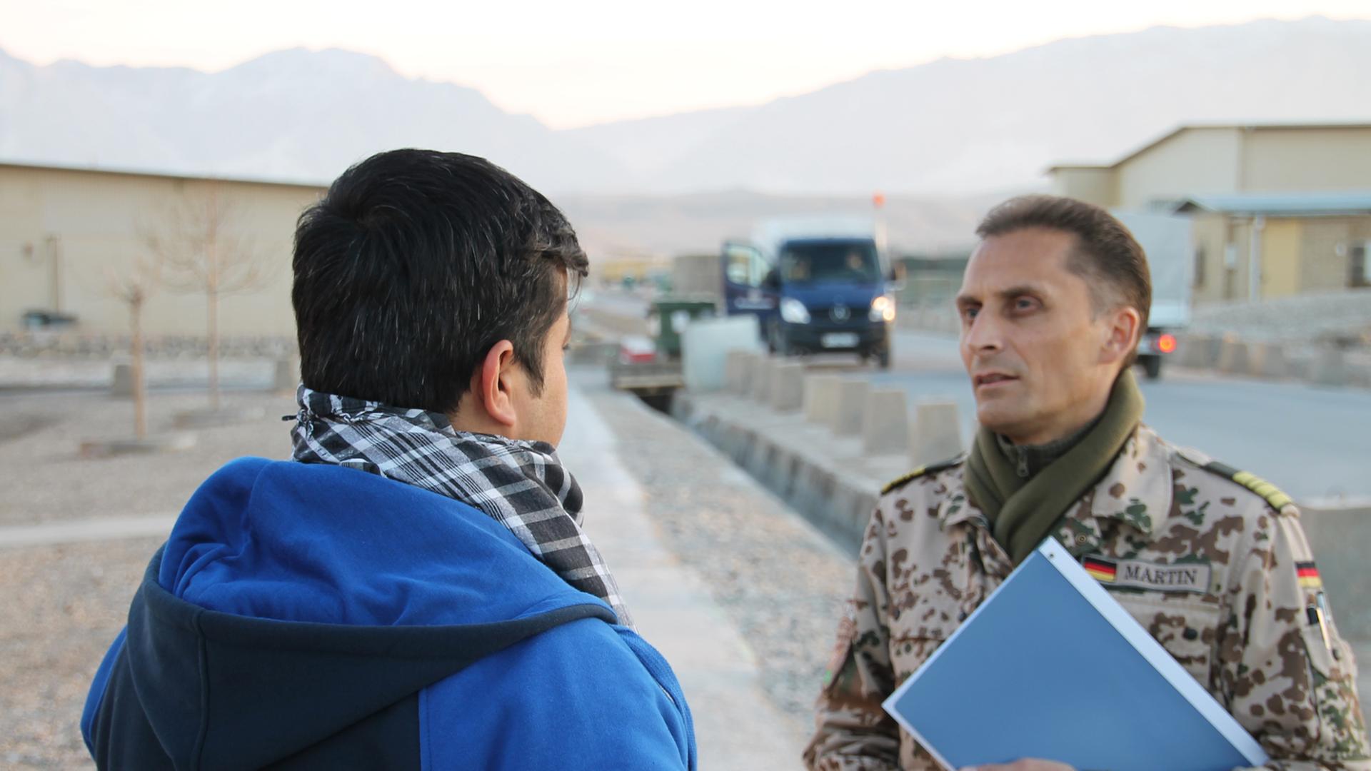 Afghanischer Helfer im Gespräch mit einem Bundeswehrangehörigem.