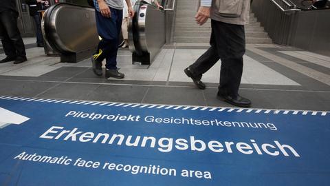 Menschen gehen durch den Bahnhof Südkreuz in Berlin, indem ein Pilotprojekt zur Gesichtserkennung installiert ist.