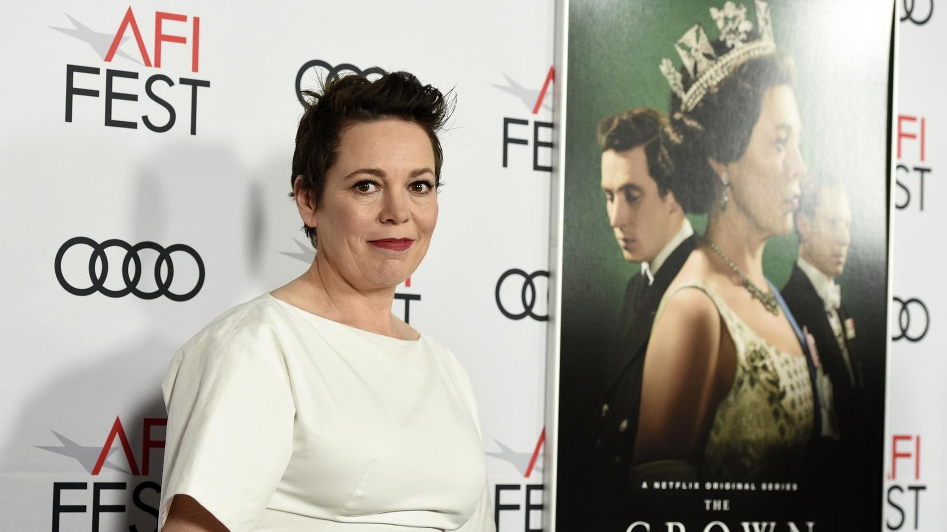 Die Schauspielerin Olivia Colman - in der Netflix-Serie "The Crown" spielt sie Queen Elisabeth II., hier bei einer Filmpremiere vor einem Plakat der Serie