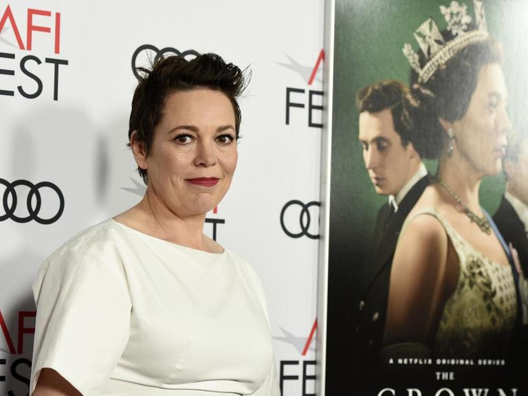 Die Schauspielerin Olivia Colman - in der Netflix-Serie "The Crown" spielt sie Queen Elisabeth II., hier bei einer Filmpremiere vor einem Plakat der Serie