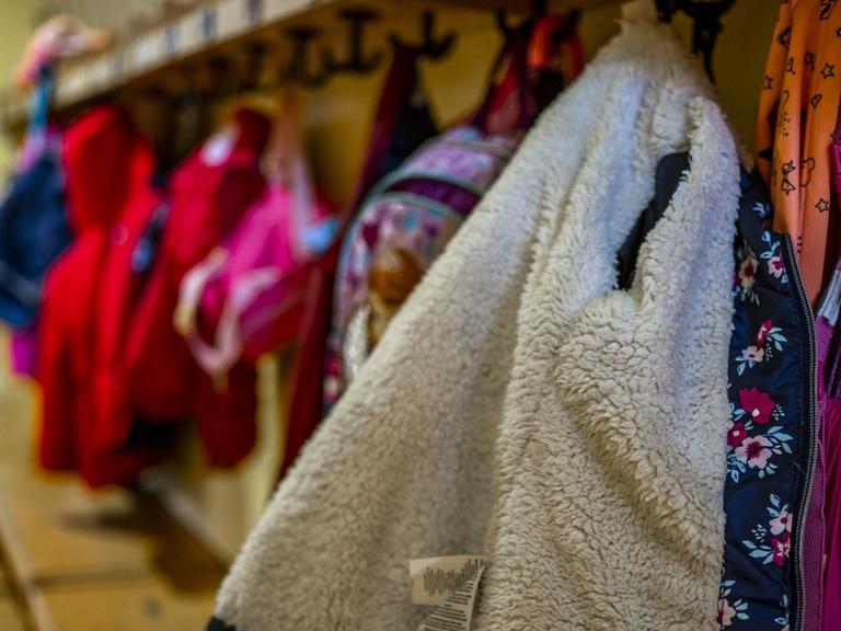 Panorama: Kinder, Kinderbetreuung: An einer Garderobe in einem Kindergarten hängen Jacken und Rucksäcke von Kindern.