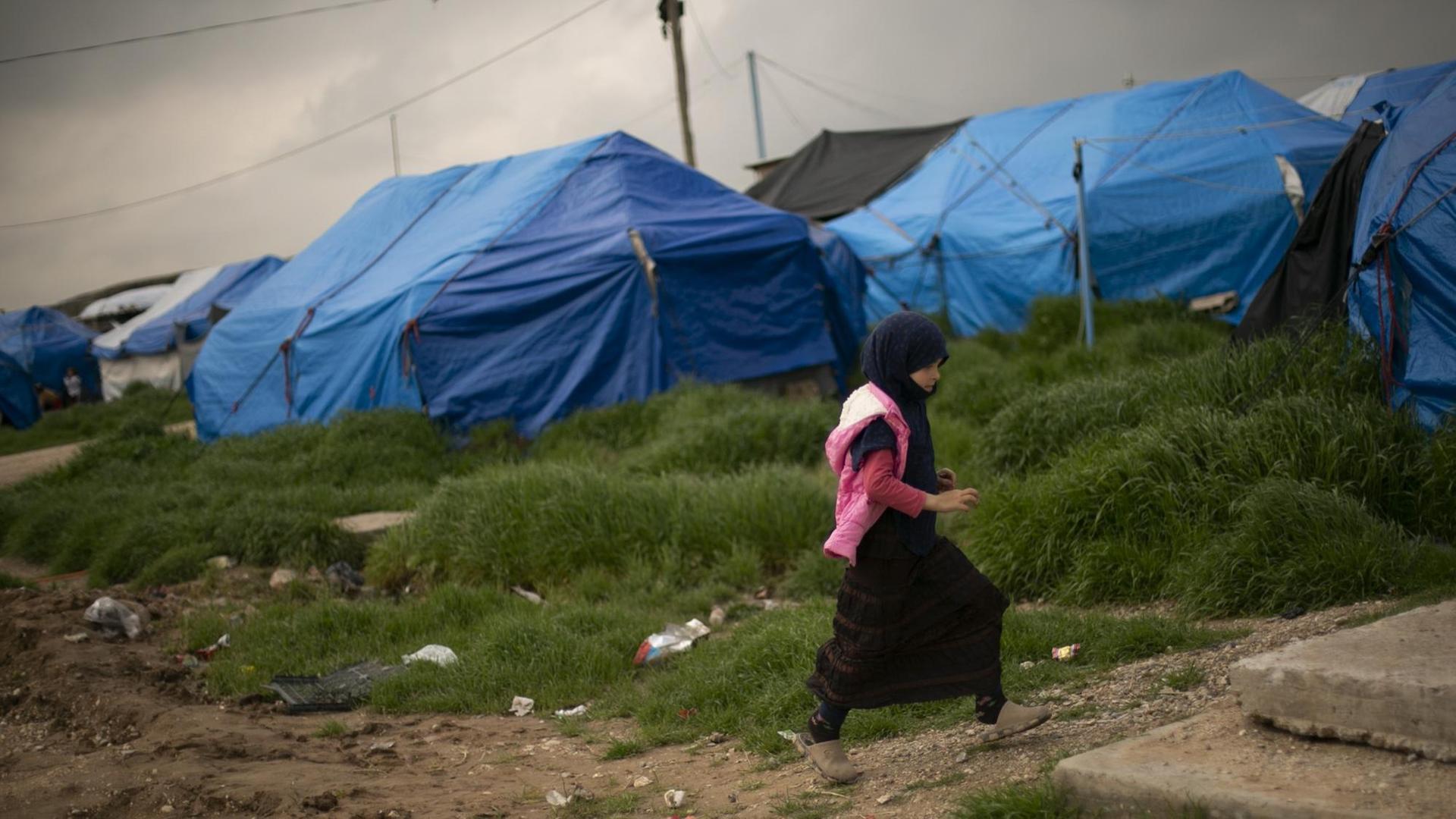Auf diesem Foto vom 27. März 2019 geht ein Mädchen durch einen Zeltbereich im Lager Roj, wo Familien von Anhängern des Islamischen Staates festgehalten werden, in der Nähe von Derik, Syrien.