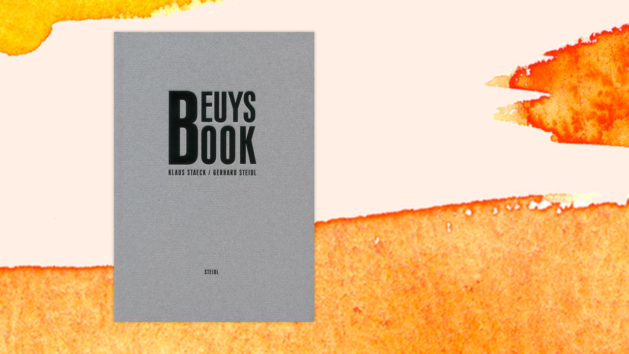 Das Buchcover von Klaus Staeck und Gerhard Steidl: „Beuys Book“ auf orange-weißem Hintergrund.