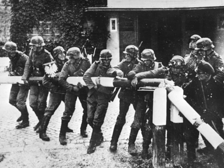 Beim Einmarsch deutscher Truppen in Polen am 01.09.1939 reißen Soldaten der deutschen Wehrmacht einen rot-weißen Schlagbaum an der deutsch-polnischen Grenze nieder.