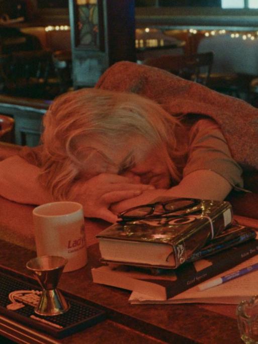 Film-Still aus "Bloody Nose, empty Pockets": Schlafender in einer Bar.