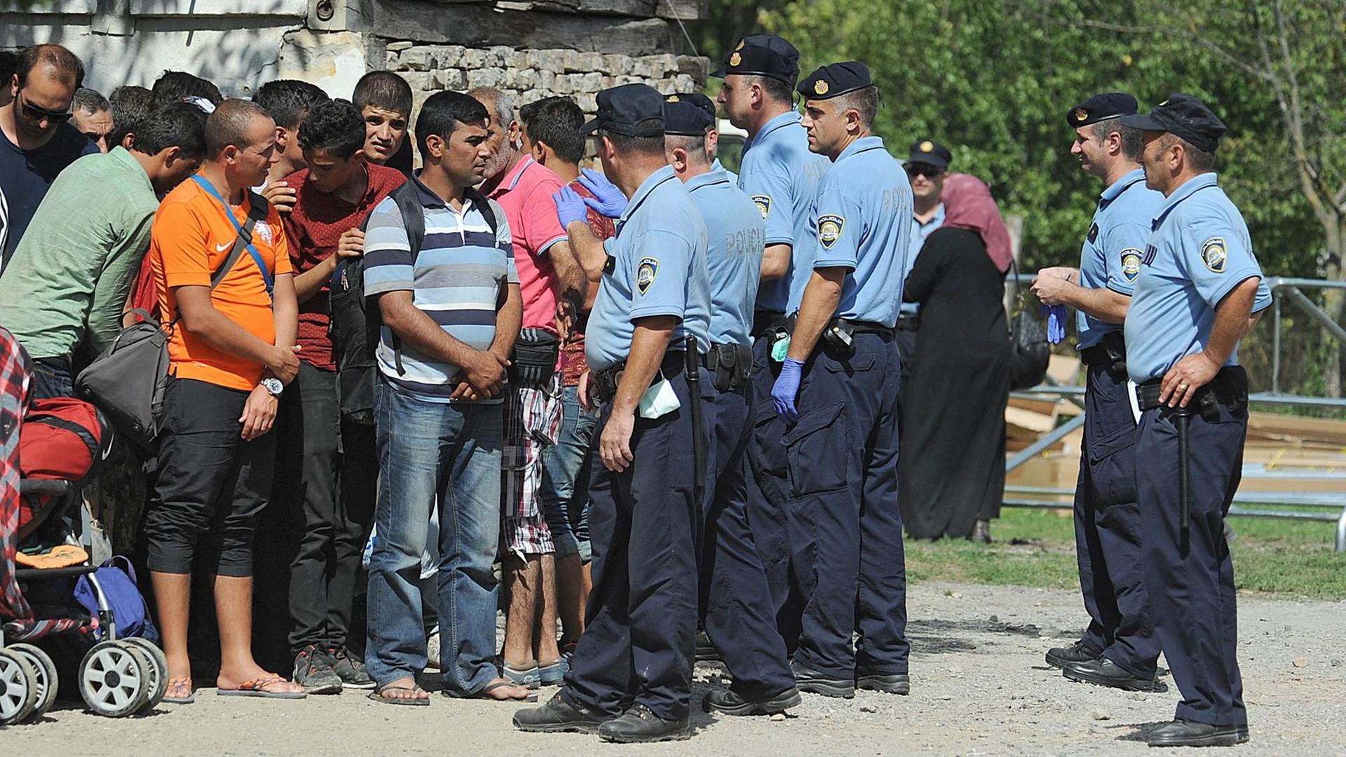 Kroatische Polizisten in der Stadt Tovarnik an der serbischen Grenze geleiten Flüchtlinge zu Bussen
