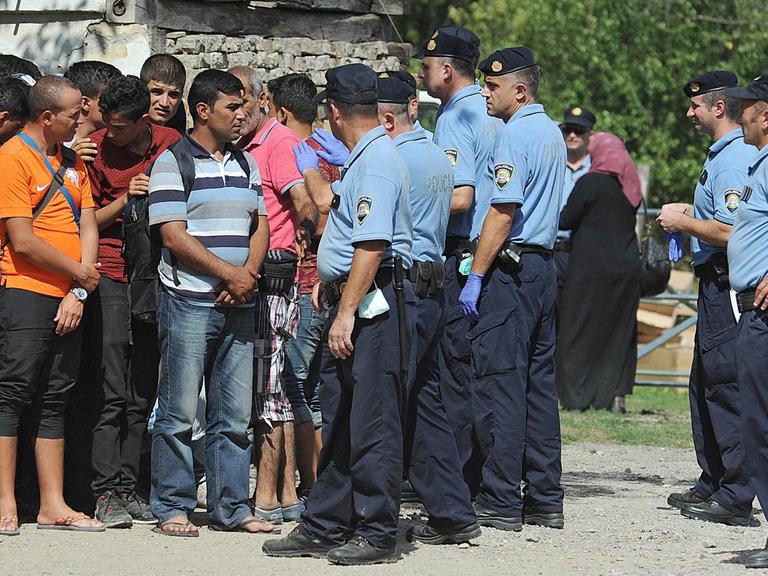 Kroatische Polizisten in der Stadt Tovarnik an der serbischen Grenze geleiten Flüchtlinge zu Bussen