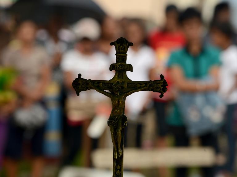 Angehörige eines bei dem Taifun Haiyan gestorbenen Philippiners trauern an seinem Grab.