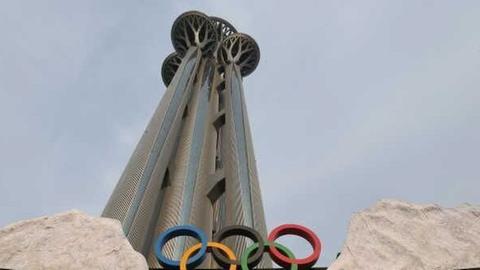 Blick von unten auf den Olympiaturm in Peking mit den Olympischen RIngen