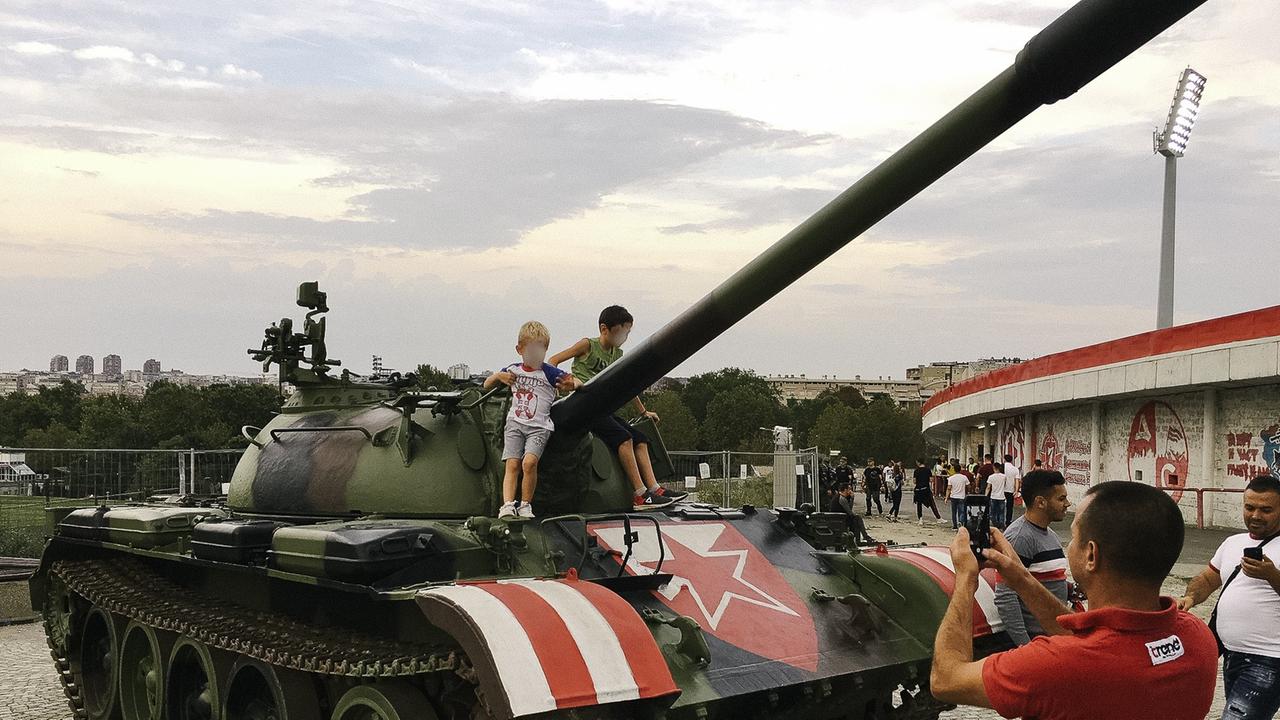 Spielende Kinder auf einem Panzer vor dem Stadion Marakan in Belgrad.