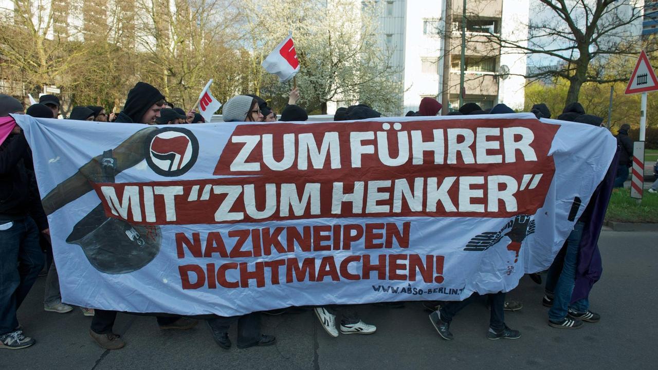 Demosntranten tragen ein Transparent mit der Aufschrift "Zum Führer mit 'Zum Henker". Nazikneipe dichtmachen".