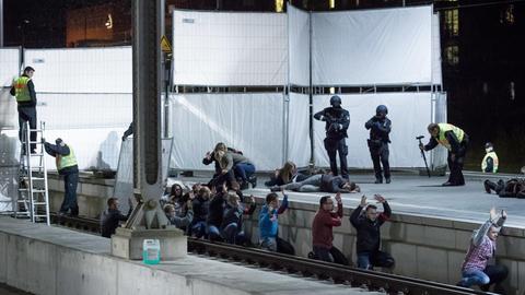 Polizeibeamte und Beobachter stehen bei einer Pressevorführung zu einer Anti-Terror-Übung im Bahnhof Lübeck auf dem Bahnsteig.