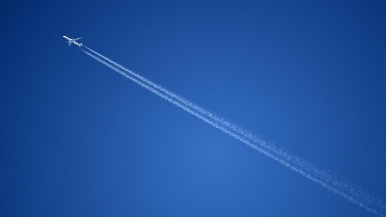 Ein Flugzeug fliegt durch den blauen Himmel.