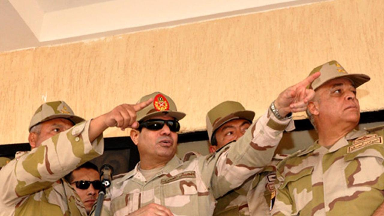 Ägyptens Armeechef Abdel Fattah al-Sisi, umringt von weiteren Militärs, deutet nach rechts.