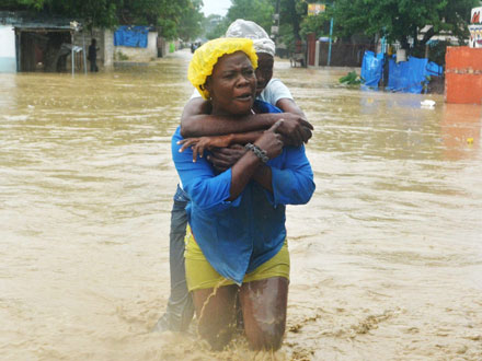 Zwei Frauen waten durch die überschwemmten Straßen von Port-au-Prince