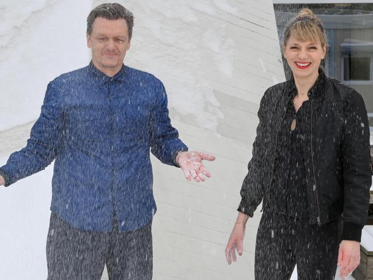 Thomas Oberender, Intendant der Berliner Festspiele, und Yvonne Büdenhölzer, Leiterin des Theatertreffens, stehen im Schnee vor dem Haus der Kulturen der Welt.