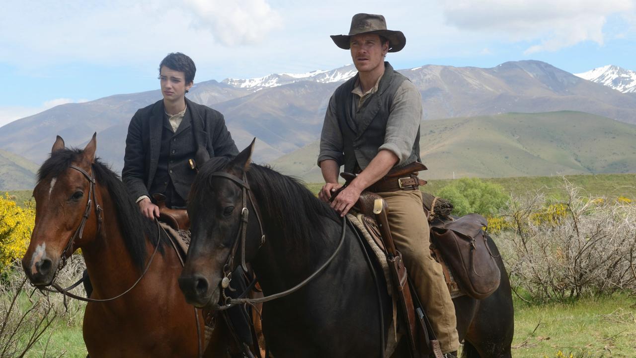 Jay Cavendish (Kodi Smit-McPhee) und Silas Selleck (Michael Fassbender) sind gemeinsam auf dem langen Weg nach Westen - eine Szene des Films "Slow West".