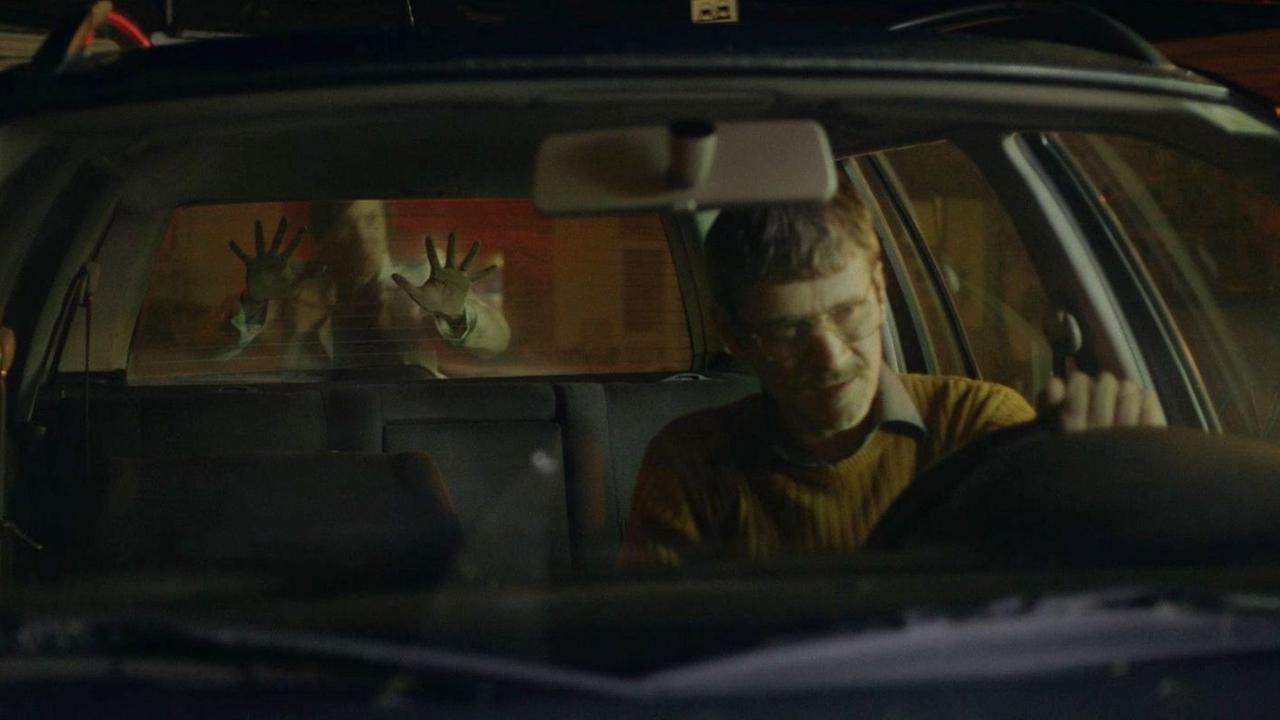 Im Still aus "Friedenszeit" legt eine Person ihre Hände an die Heckscheibe eines Autos.