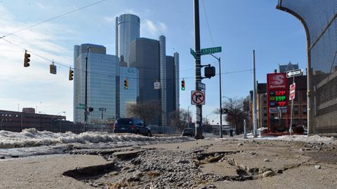 Sanierungsbedarf an allen Ecken: Die einst floriende Auto-Industriestadt Detroit steht kurz vor der Pleite. Aufgerissene Straße, im Hintergrund Hochhäuser.