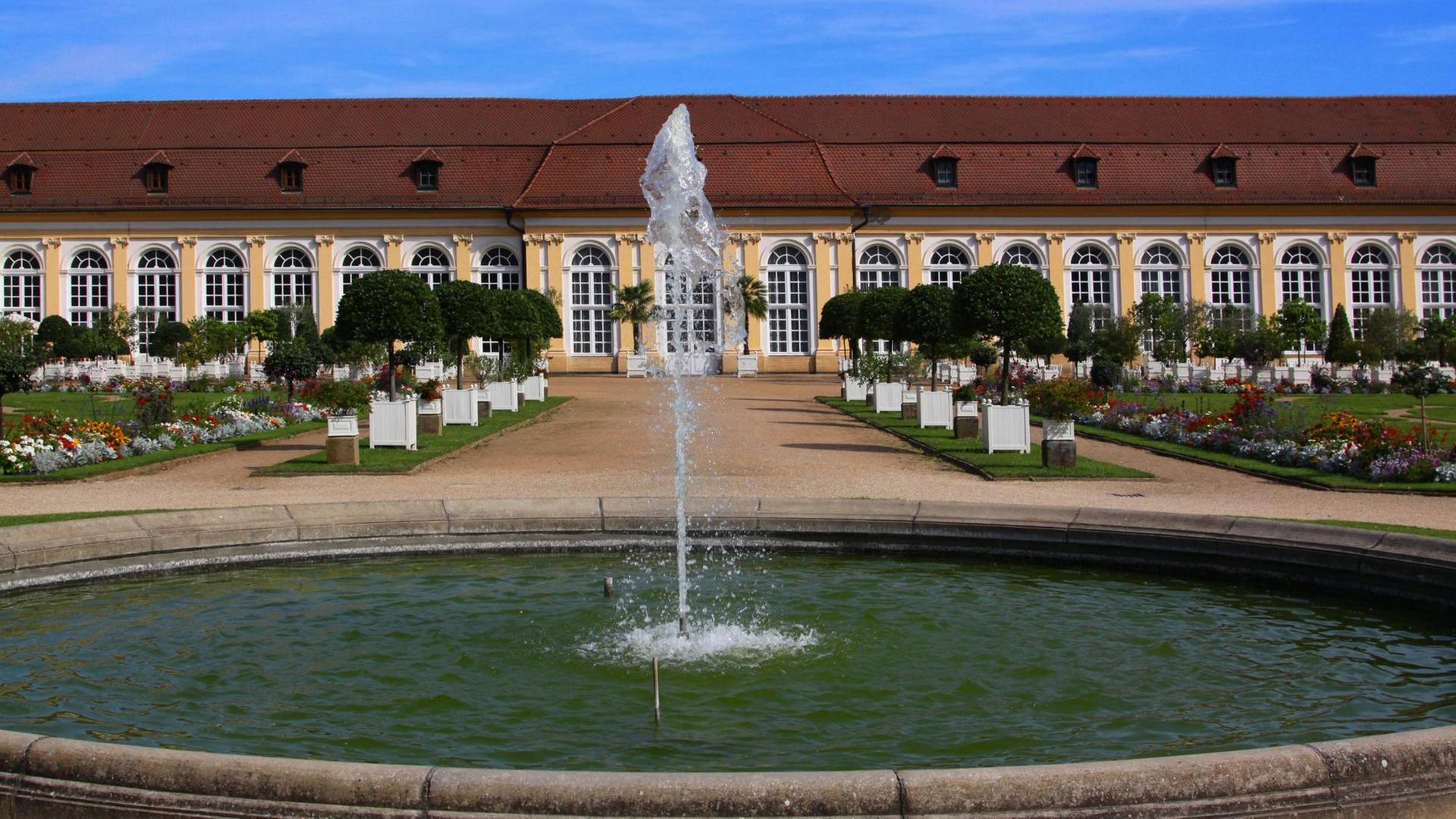 Blick auf die barocke Front der Orangerie des Schlosses Ansbach mit einer Wasserfontäne im Vordergrund