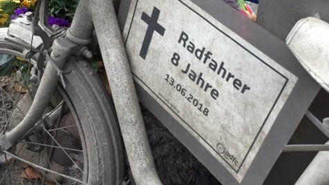 "Radfahrer 8 Jahre, 13. Juni 2018“,  steht auf einem Schild, das an einem kleinen weißen Fahrrad hängt