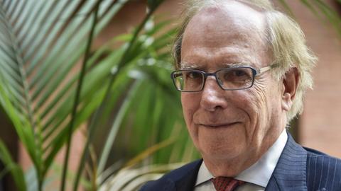 Der kanadische Sportrechtler Richard McLaren schaut in die Kamera, im Hintergrund Palmen
