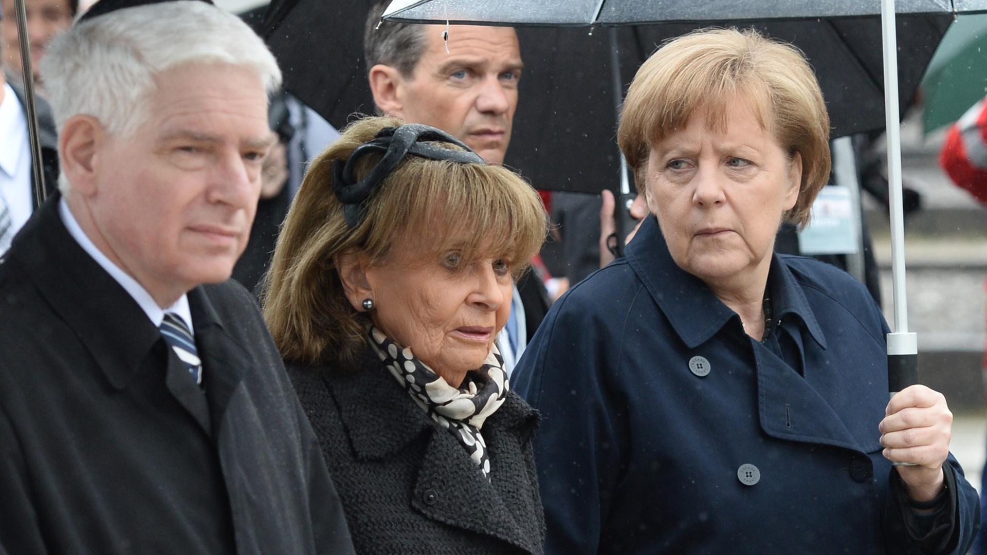 Bundeskanzlerin Angela Merkel (r, CDDU) geht am 03.05.2015 mit dem Präsidenten des Zentralrats der Juden, Josef Schuster (l), und der Präsidentin der Israelitischen Kultusgemeinde München und Oberbayern, Charlotte Knobloch, zur Zentralen Gedenkfeier anlässlich des 70. Jahrestags der Befreiung des Konzentrationslagers Dachau auf dem ehemaligen KZ-Gelände in Dachau (Bayern).